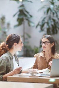Two young businesswomen discussing buy /sell protection.