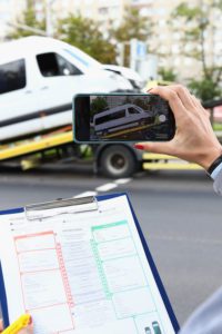 Individual taking photo of their commercial shuttle bus being towed away.