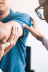 Doctor examining patient's injured elbow.