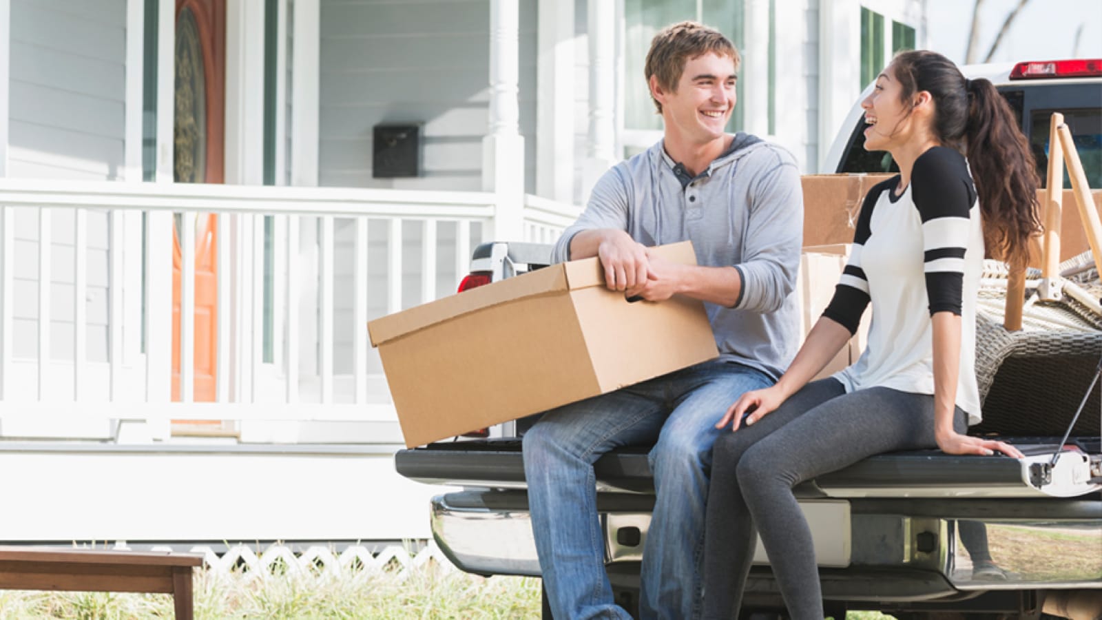 pick-up-large Young couple sitting on a pickup truck tailgate