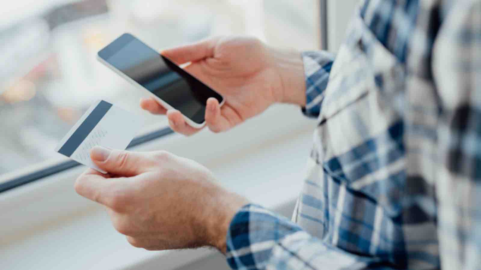 Man holding a credit card and a smartphone