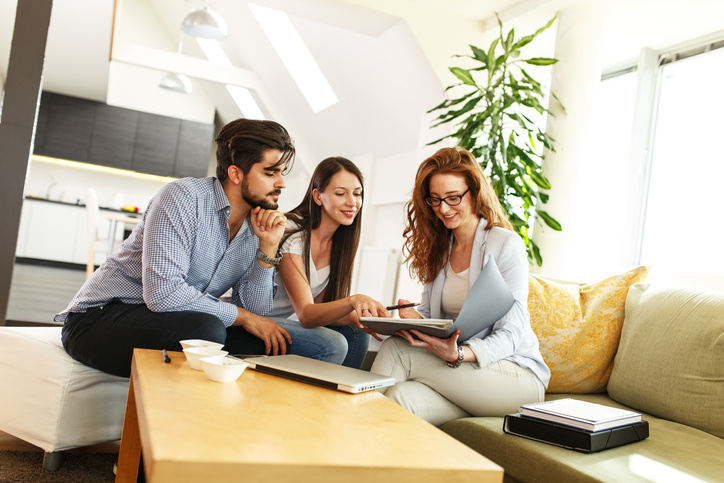 Real Estate Young Couple Reviewing Documents With Consultant