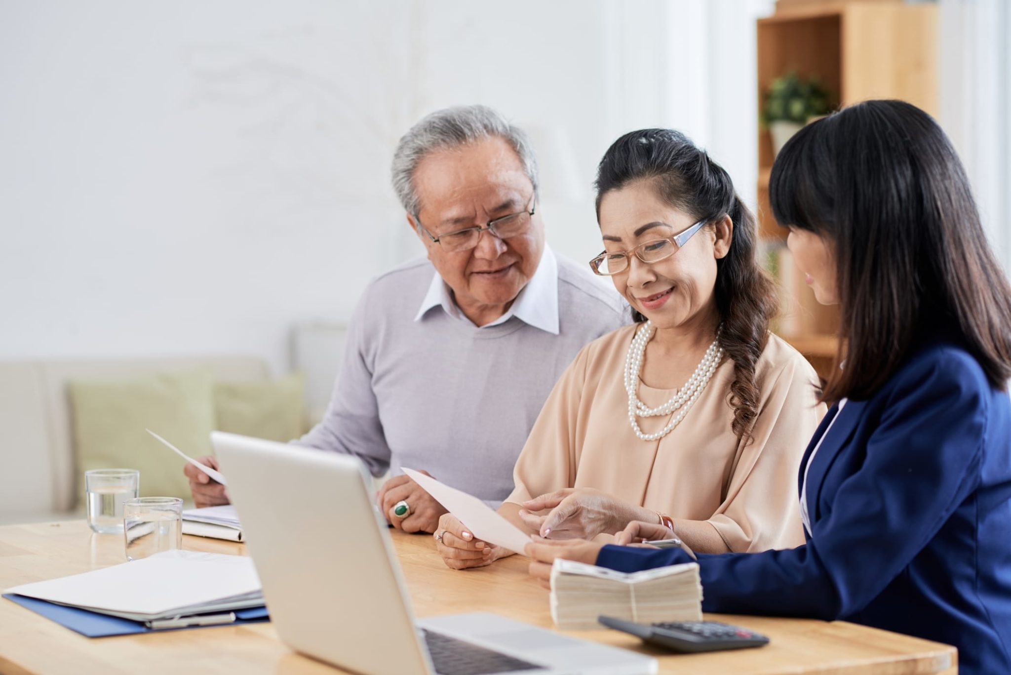 GettyImages-1007808178 Happy Asian Couple Speaking With Advisor