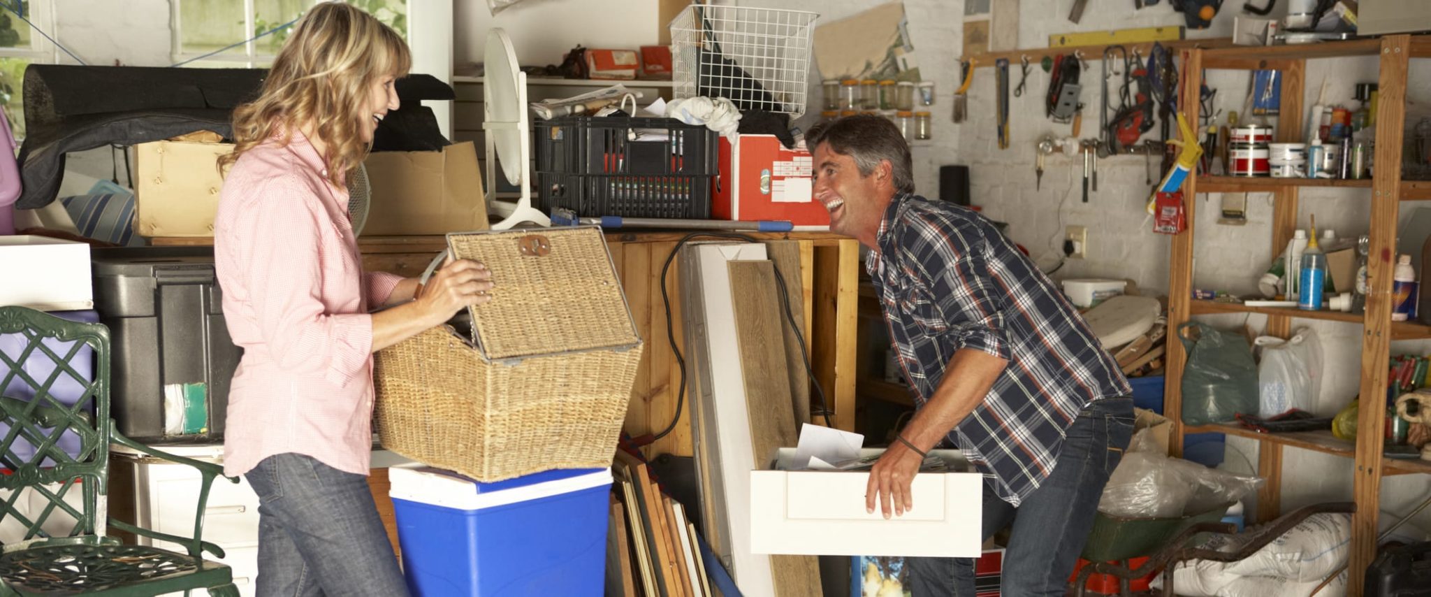 6 Things You Shouldn’t Store In Your Garage Happy Man and Woman Storing Objects in Garage