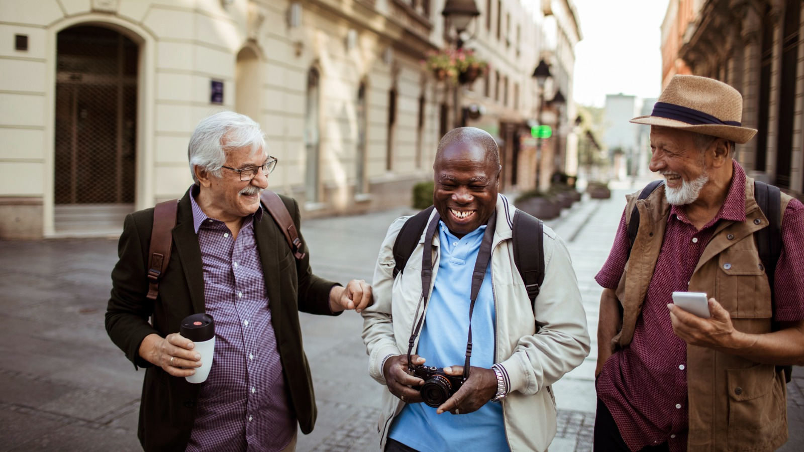 3 senior friends laughing 3 males in another country