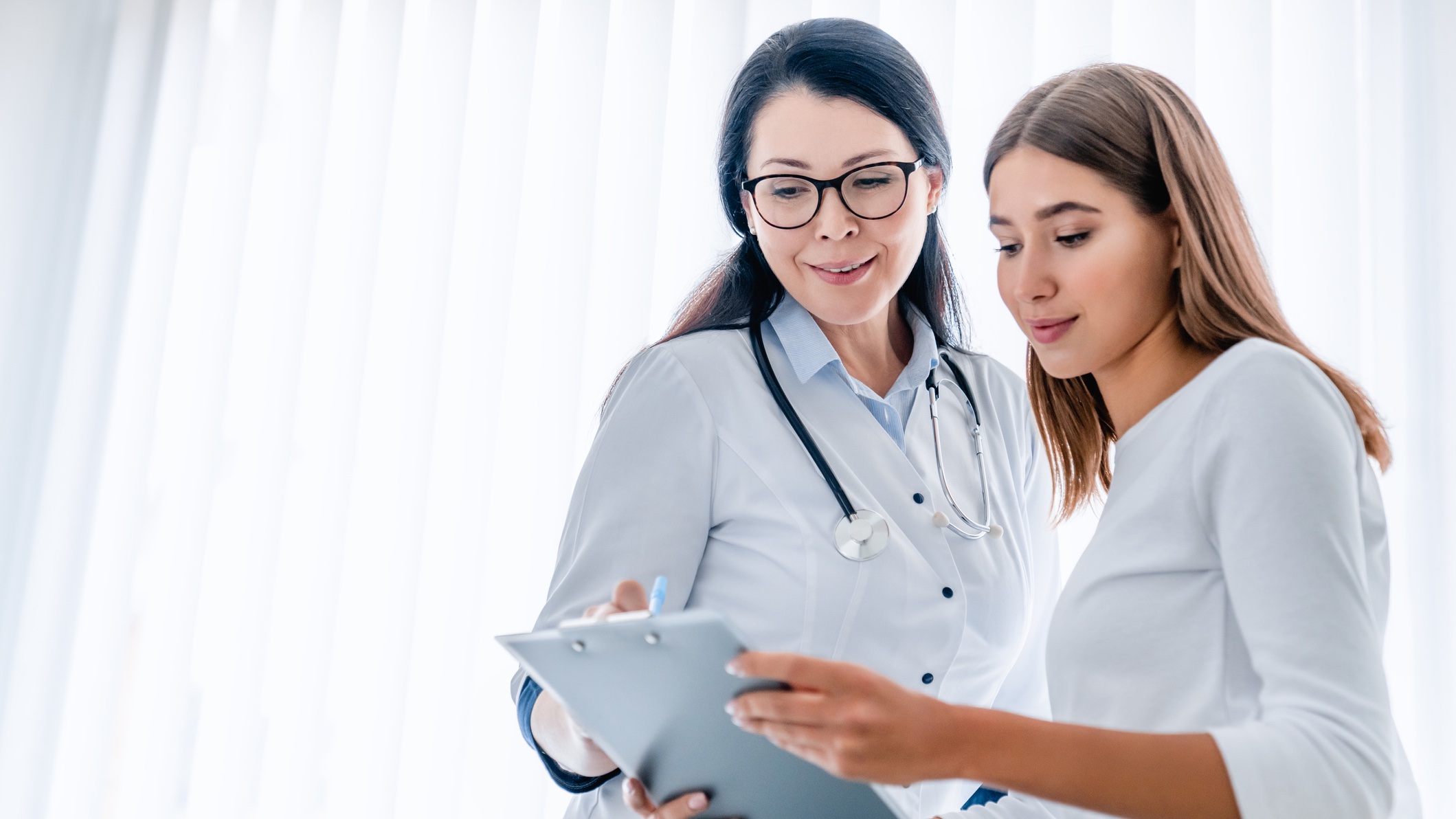 doctor and patient two women looking at medical records