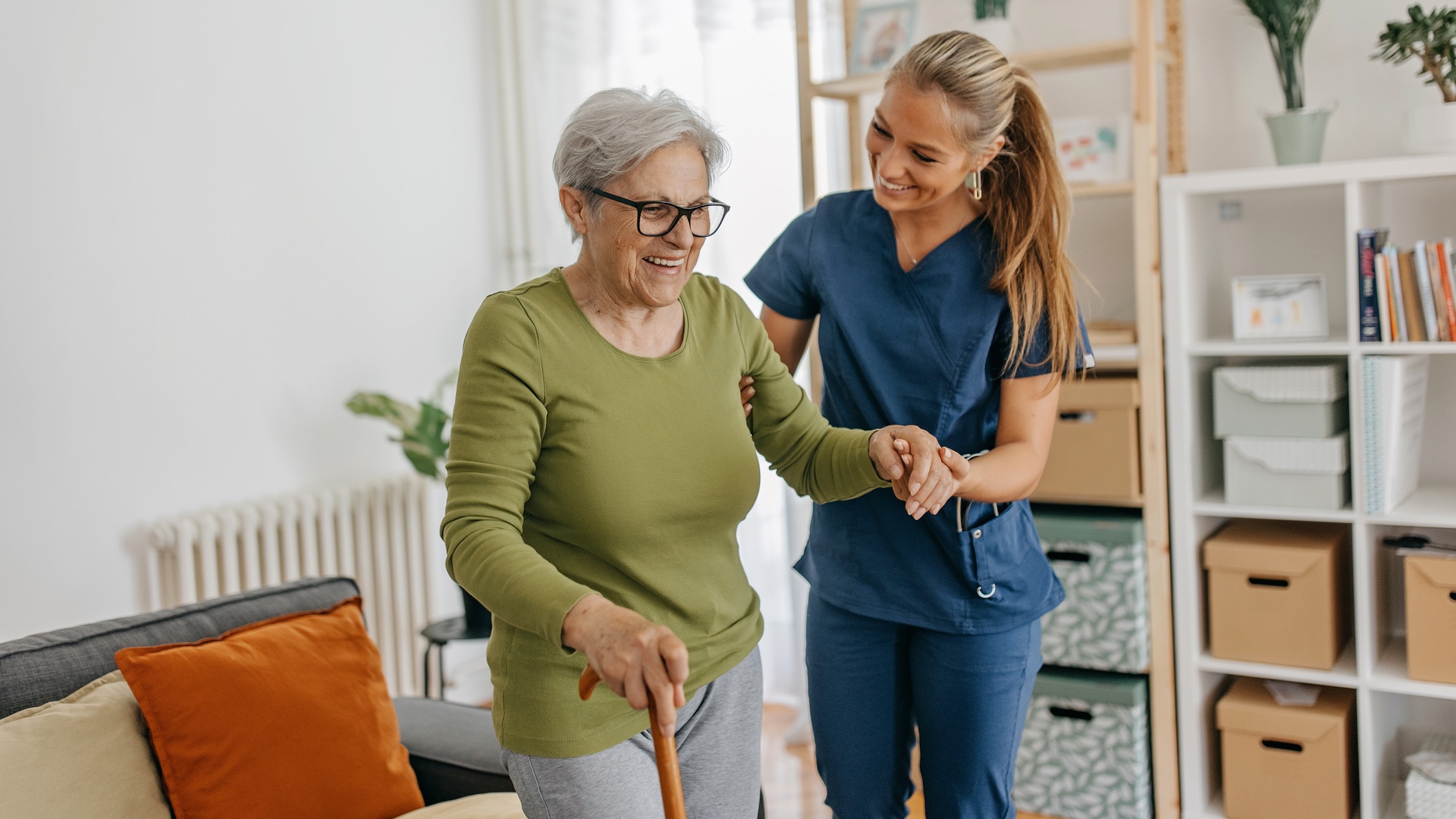 Happy Senior woman walking on cane Nurse helping senior woman