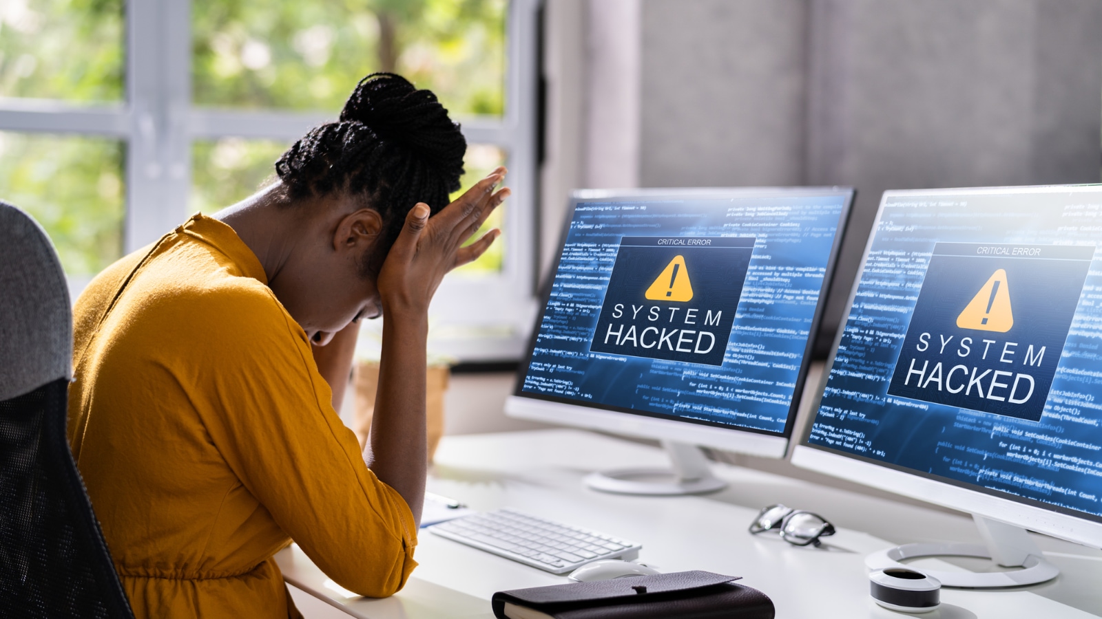 cyber attacks frustrated woman with two computers that have been hacked