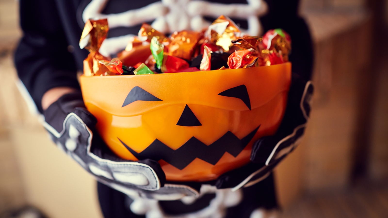 costumes candy care child in skeleton costume with a bowl of candy