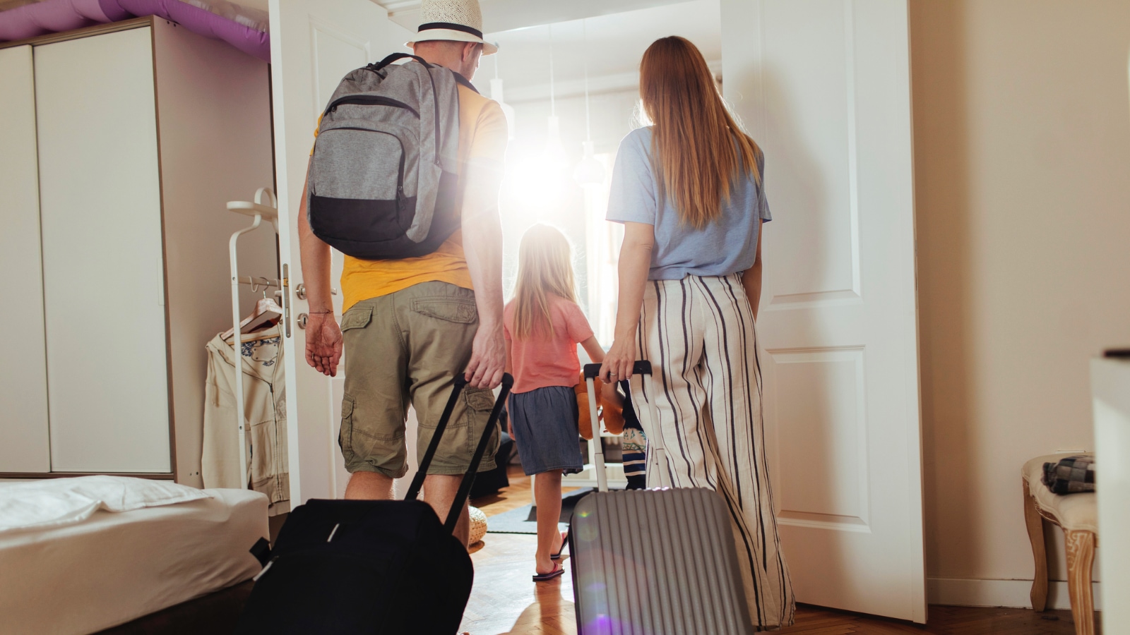 traveling for the holidays family of three leaving the house with luggage